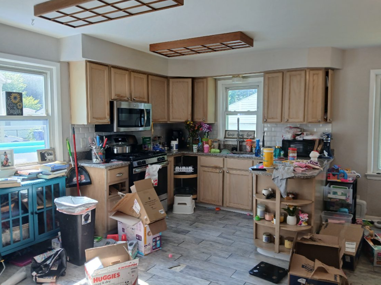 Kitchen before cleaning - cluttered with boxes and items scattered everywhere
